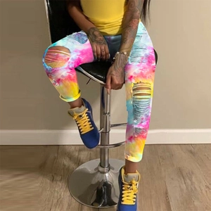 Detail shot of street style ripped jeans featuring colorful tie-dye patterns and distressed holes