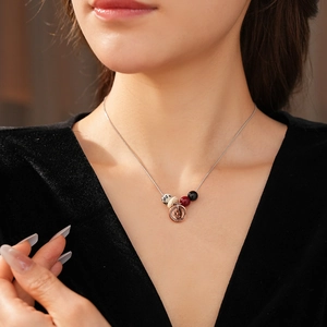 Close-up of bohemian beaded necklace with speckled stone and rose gold pendant on model