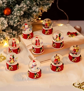 Detail of assorted Christmas snow globes with Santa and reindeer on festive red resin bases