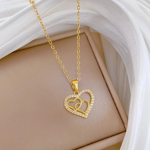Close-up of gold heart pendant necklace with shimmering crystals on a jewelry box
