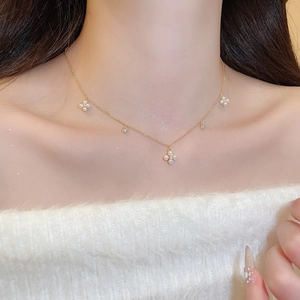 Detail of elegant gold-plated floral necklace with small zircons and pearls on model