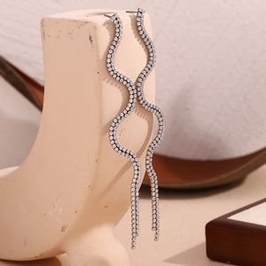 Macro shot of silver crystal wave tassel earrings with detailed zircon inlay and shine
