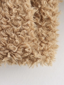 Gros plan sur la texture bouclée en similicuir d'une veste en polaire camel clair