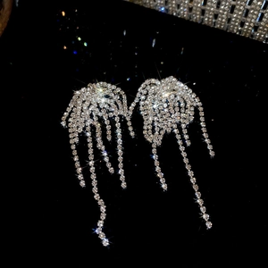 Macro shot of silver rhinestone tassel earrings with sparkling diamond fireworks design