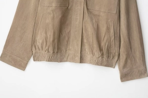 Détail du bas de la veste en daim marron avec taille élastique et poches latérales