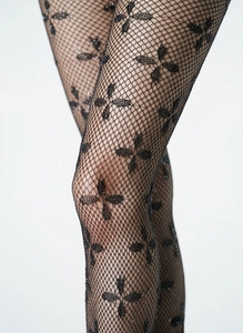 Detail von schwarzen Gothic-Netzstrumpfhosen mit glitzerndem Kleeblatt-Muster und Netz