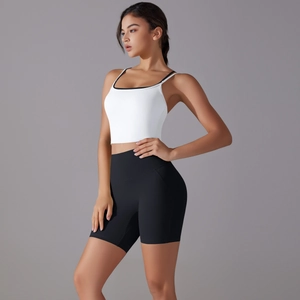 Detailed side view of white yoga tank top and black high-waisted fitness biker shorts set