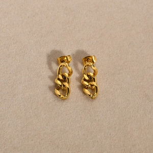 Detail of elegant gold triple link drop earrings with high-polish metallic finish