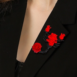 Gothic style red rose brooch with black alloy leaves on a black suit lapel
