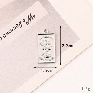 Macro detail of rectangular silver queen coin pendant with embossed portrait and ring loop