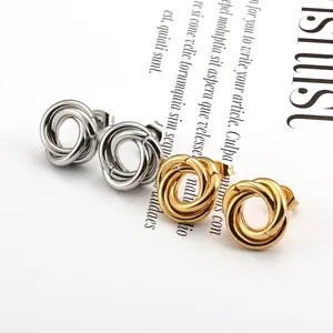Polished gold and silver twisted spiral stud earrings on a minimalist background