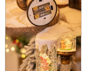 Close-up of the base and battery compartment of a Christmas snow globe candle light