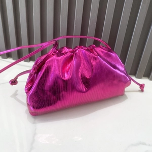 Detail of metallic rose red cloud bag with pleated texture and drawstring closure