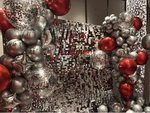 Silver shimmer wall with red Merry Christmas signage and decorative party balloon arch