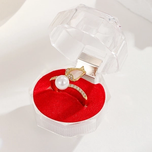 Detail of 18K gold tulip ring with sparkling zircon and pearl in a red jewelry box