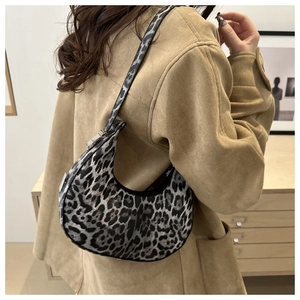 Detailed view of leopard print underarm bag with soft texture worn with camel coat