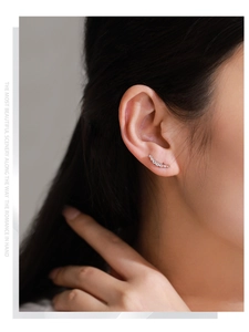 Close-up of a model wearing a curved S925 silver earring with white cubic zirconia stones