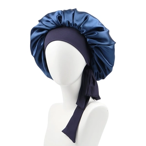 Detail of dark blue satin sleep cap with purple elastic headband and long ribbon ties