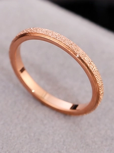 Detailed close-up of rose gold ring showing frosted texture and polished steel finish