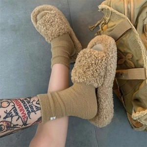 Detail of plush fleece socks and slippers in warm beige tones for autumn and winter comfort