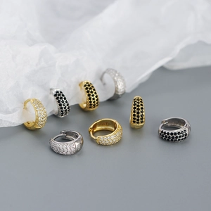 Detailed view of U-shaped huggie hoops in gold and silver with micro-pave cubic zirconia