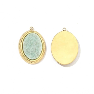 Detail of oval pendant with turquoise stone inlay and polished gold-plated stainless steel back