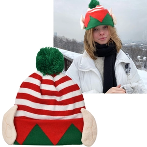 Detail view of festive striped Christmas elf hat with pom pom and ears decoration.