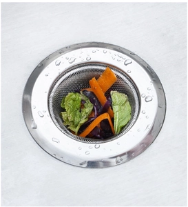 Close-up of stainless steel kitchen sink strainer filtering food waste and vegetable scraps