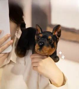 Close-up of cute realistic plush dog toy with soft texture and bright eyes in hand