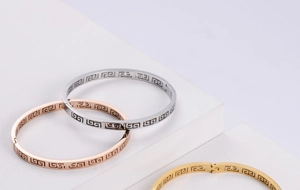 Macro detail of geometric cutout bangles in silver, rose gold and gold finishes