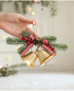 Details von goldenen Weihnachtsglocken mit rot gestreiften Schleifen und Kiefernnadeln