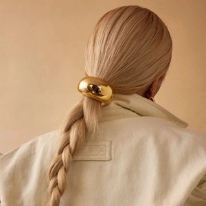 Polished gold stainless steel hair ring on model's braided ponytail in high gloss finish