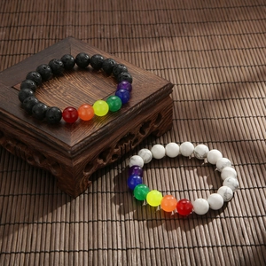 Dettaglio di sette perle energetiche chakra su lava vulcanica e bracciali in turchese