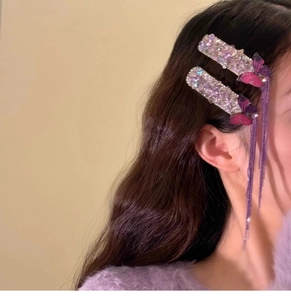 Detailed side view of purple butterfly hair clips with long tassels on a model hair style