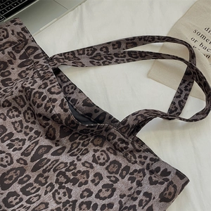 Macro detail of vintage leopard print suede tote bag with durable shoulder strap design