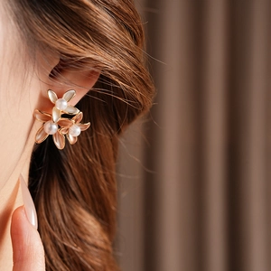 Detailed view of flower earrings with gold plating, opalescent petals and central pearl