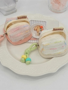 Tweed-style cute portable fabric pouches for wireless earphone storage in pink and cream.
