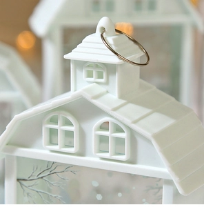 Close-up of a white decorative house lantern with metal hanging ring and warm LED bokeh