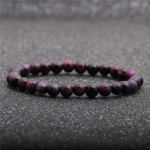 Dettaglio macro del bracciale in perle occhio di tigre viola con texture liscia