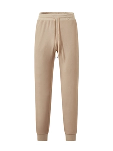 Detailed view of khaki waffle knit texture on men's jogger pants with drawstring waist