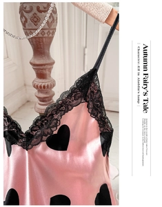 Détail de nuisette en satin rose avec imprimé cœur noir et bordure en dentelle