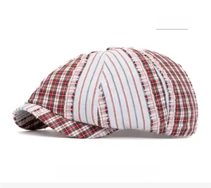 Detail of red newsboy cap featuring patchwork plaid and striped patterns in retro style
