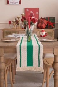 Close-up of beige and green striped linen table runner with tassels for Christmas table decor