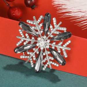 Macro shot of silver snowflake brooch with sparkling crystals and grey teardrop stones