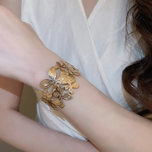 Dettaglio macro del bracciale a fiore traforato oro vintage con petali di metallo al polso