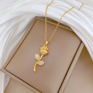 Macro shot of rose gold necklace with crystal pavé rose pendant on beige jewelry box