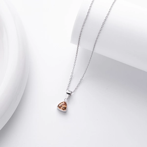 Detail of a minimalist S925 silver necklace with amber triangle gemstone pendant