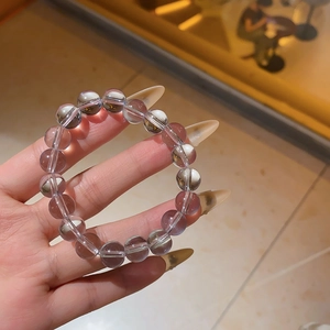 Close-up of a minimalist clear crystal beaded elastic bracelet with smooth round beads