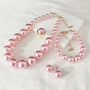 Detailed set of pink faux pearl necklace, bracelet, ring, and earrings with gold finish
