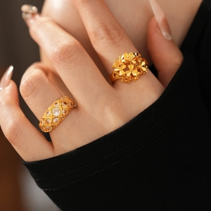 Detailed close-up of 24k gold plated flower ring and pave-set zircon band on finger